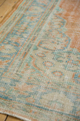Distressed vintage Oushak rug, tangerine, seafoam, and ivory tones revealing knot heads.