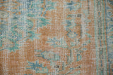 Vintage distressed Oushak carpet pile, showing wear and muted tangerine, seafoam, and blue tones.
