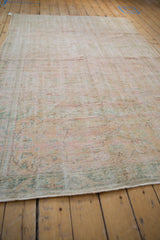 Worn pile of a distressed Oushak rug, showing faded vinery in pale mint and ivory.