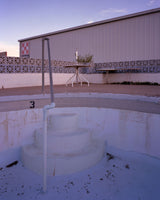 Joe Farrell's 'Empty Pool' photograph showing a weathered blue pool and industrial building at twilight.