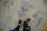 Vintage distressed Oushak carpet with worn pile, ivory field, pale blue and green patterns.