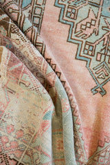 Distressed vintage Oushak rug texture revealing worn blush, green patterns and foundation.