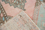 Distressed blush Oushak rug pile texture with geometric motifs and hand-knotted back.
