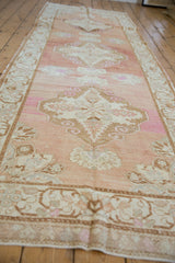Distressed Oushak runner detail: low pile, abrashed peach field, scrolled ram's horn motifs.