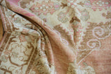 Distressed Oushak runner pile with worn texture, showing scrolled motifs in ivory, pink, brown.
