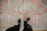 Distressed Oushak rug texture, with visible knot heads and faded blush, ivory, and slate patterns.