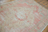 Distressed Oushak rug with worn pile texture in beige, blush, and faint slate tones.