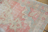 Close-up of distressed vintage Oushak rug showing brick red, ivory, and slate pile wear.