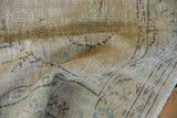 Distressed vintage Oushak rug with worn pile, visible foundation, beige, ivory, and blue.