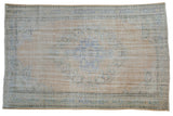 Vintage distressed Oushak carpet with a shadow medallion in pale blue and apricot on a worn beige field.