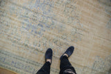 Time-softened texture of a distressed Oushak rug with visible knot heads in beige and pale blue.