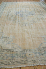 Low-angle view of the distressed vintage Oushak showing its hand-knotted texture and low pile.