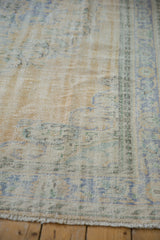Close-up of the distressed Oushak's low pile, showing mostly even wear and visible foundation.