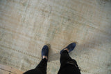 Distressed Oushak carpet with textured pile, even wear, and muted beige and pale seafoam.
