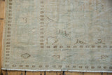 Distressed vintage Oushak pile shows mostly even wear, pale seafoam, beige tones, and secured fringe.