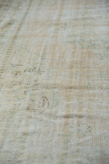 Textural distressed pile of the Oushak rug, revealing pale beige, ivory, and seafoam hues.