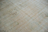 Distressed Oushak carpet pile texture, showing mostly even wear in soft beige, ivory, and seafoam.
