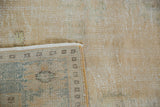 Worn beige Oushak pile revealing foundation, intact selvage, and short fringe.