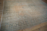 Distressed vintage Oushak rug with visible foundation wear, sandalwood, and sage green palmettes.