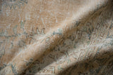 Distressed vintage Oushak carpet showing textured pile, faded floral vinery, and soft green tones.
