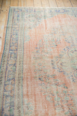 Vintage Distressed Oushak carpet with worn dusty blush field and faded royal blue border.