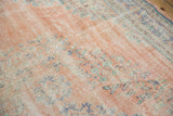 Distressed vintage Oushak carpet, showing worn pale melon pile with faded blue, mint motifs.