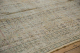 Distressed Oushak rug with low pile, foundation visible, and pale floral lattice motifs.