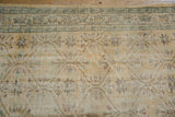 Distressed Oushak carpet detail showing worn texture, foundation, and muted geometric floral motifs.