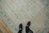 Vintage distressed Oushak with faded floral bouquets and palmette border in ivory, teal, brown.