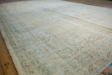 Distressed texture of a vintage Oushak carpet, with faded mint green and coffee brown designs.