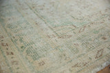 Distressed Oushak rug pile texture showing knot heads, ivory, mint green, pale brown.