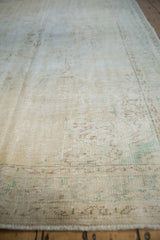 Distressed vintage Oushak carpet pile showing wear to foundation, with fringe visible.