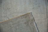 Oushak rug reverse; showing sturdy foundation, secured selvage, and distressed ivory pile.