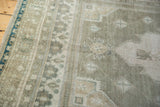 Vintage distressed Oushak rug border, showing worn pile, seafoam, ivory, and blue.