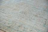 Distressed Oushak carpet pile's heavy wear, revealing faded beige and teal.