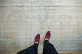 Distressed vintage Oushak carpet with worn texture in faded seafoam green and peach.