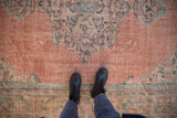 Distressed Oushak carpet, pale blush field with soft green, aqua, and coffee brown patterns.
