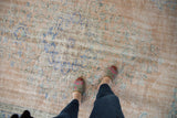 Distressed Oushak carpet texture, pale blush and blue floral bouquets, with even wear.