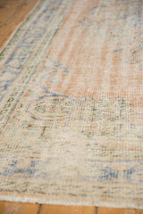 Distressed vintage Oushak pile showing even wear across knot heads and faded hues.