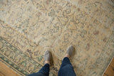 Distressed vintage Oushak carpet with faded scrolling vinery, cloud-bands, and ivory, sea foam tones.
