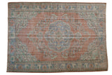 Distressed vintage Oushak rug, scalloped floral medallion in faded terracotta, blue, ivory. 6'8