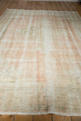 Distressed Oushak carpet showing even wear across knot heads and faded pale rose.