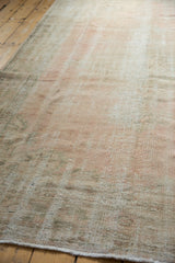 Textured surface of the vintage distressed Oushak, highlighting mostly even pile wear in soft tones.