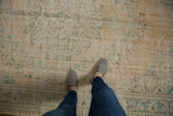 Distressed vintage Oushak rug with mostly even wear, faded beige, ivory, and mint green.