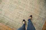 Textured distressed Oushak carpet, soft ivory field with faded mint green patterns.