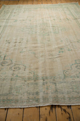 Distressed pile texture and short fringe with faded sea foam green patterns.