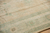 Distressed vintage Oushak carpet detail: mostly even wear, faint foundation, sea foam green motifs.