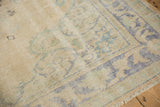 Distressed vintage Oushak rug's worn ivory field and faded blue-green border.