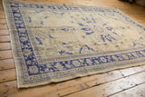 Distressed vintage Oushak rug corner, deep cobalt blue border and aged ivory field.