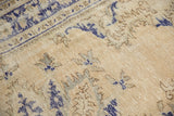 Worn distressed texture of the Oushak carpet in ivory, coffee, and cobalt blue.